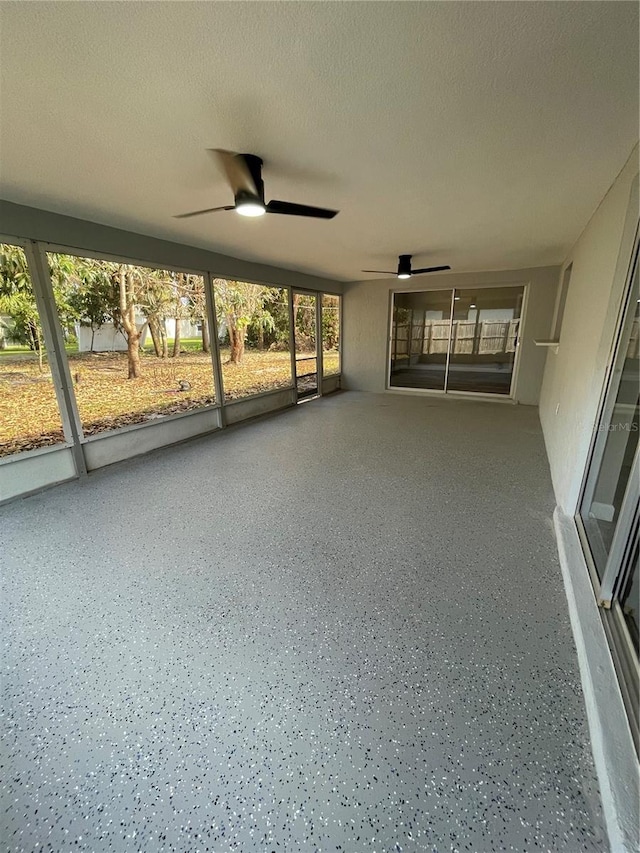 unfurnished sunroom featuring ceiling fan