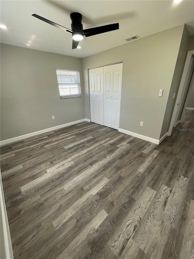 unfurnished bedroom featuring a closet, ceiling fan, and dark hardwood / wood-style flooring