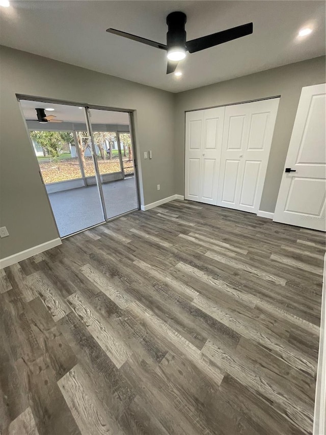 unfurnished bedroom featuring a closet, dark hardwood / wood-style floors, access to exterior, and ceiling fan