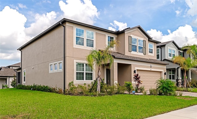 view of front of home featuring stucco siding, a garage, driveway, and a front yard