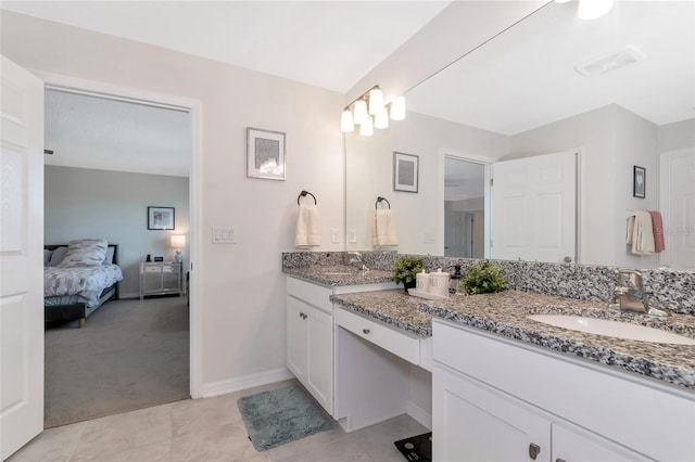 ensuite bathroom with a sink, baseboards, double vanity, and ensuite bathroom