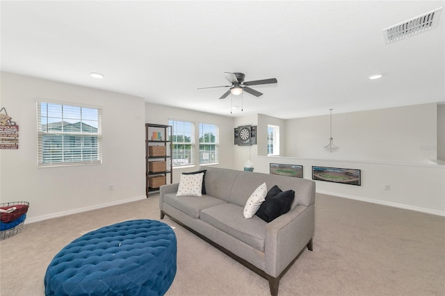 carpeted living room with ceiling fan