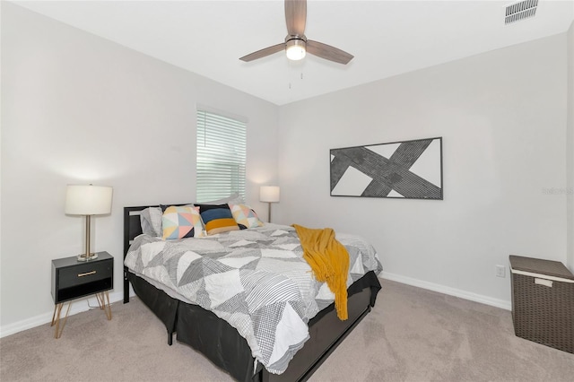 bedroom with baseboards, visible vents, ceiling fan, and light carpet