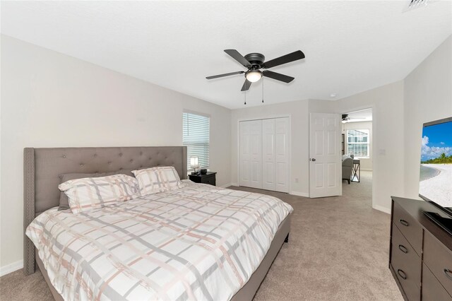 bedroom featuring ceiling fan and light carpet