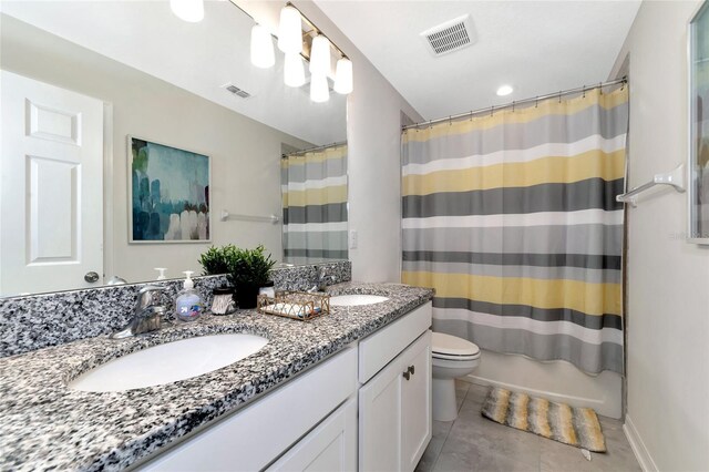 full bathroom featuring tile patterned flooring, vanity, shower / bath combo, and toilet