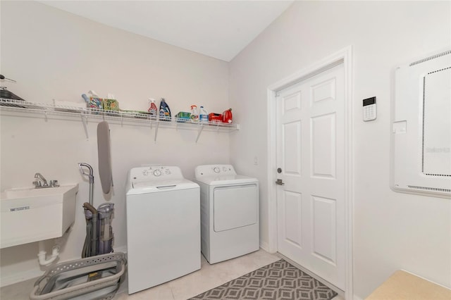 laundry area with a sink, laundry area, washer and clothes dryer, and light tile patterned flooring