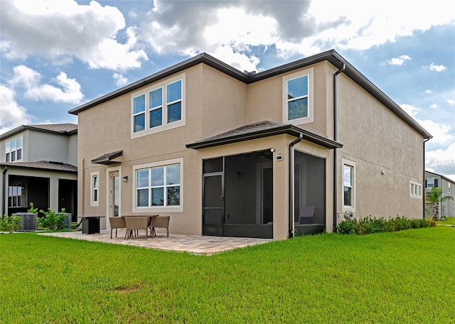 rear view of house featuring stucco siding, a patio, a lawn, and central AC