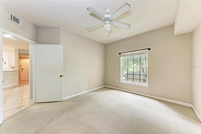 spare room featuring light colored carpet and ceiling fan