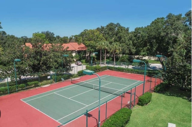 view of tennis court featuring a yard