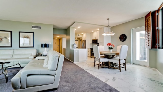 living room with a wealth of natural light, a notable chandelier, and light tile patterned floors