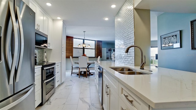 kitchen featuring white cabinetry, appliances with stainless steel finishes, sink, and tasteful backsplash