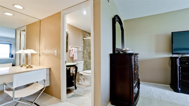 bathroom with toilet, vanity, and tile patterned floors