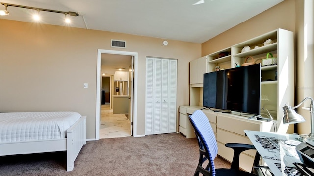 bedroom with light colored carpet and a closet