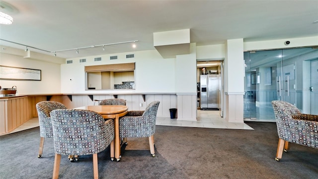 dining space with carpet and track lighting