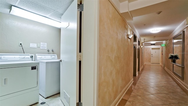 laundry area featuring light tile patterned floors and washing machine and dryer