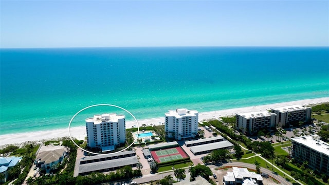 birds eye view of property with a water view and a beach view