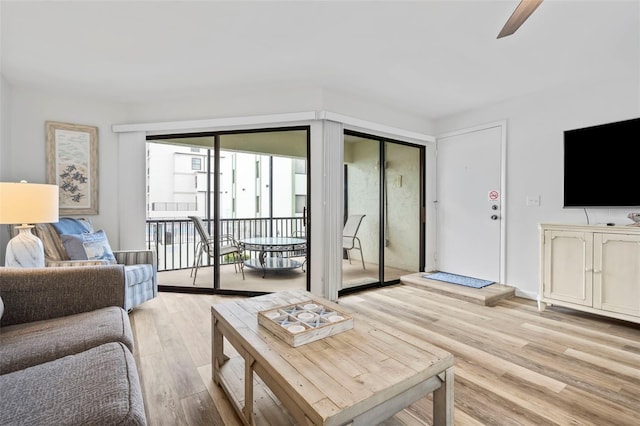 living room featuring light wood-type flooring and ceiling fan