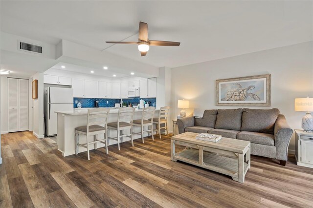 living room featuring ceiling fan and hardwood / wood-style flooring