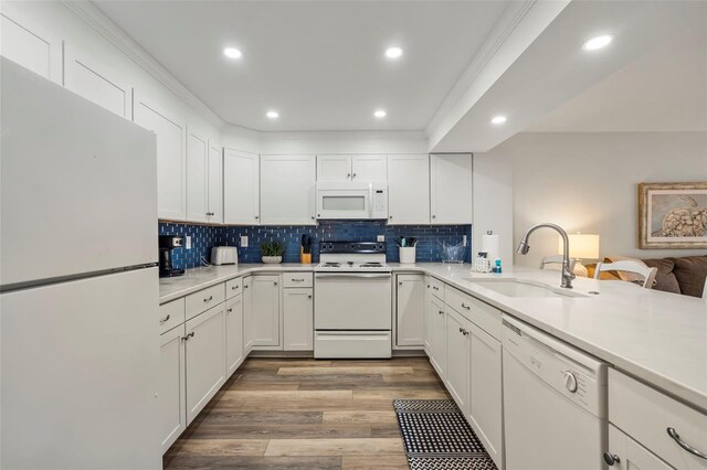 kitchen featuring light wood-type flooring, white appliances, sink, decorative backsplash, and white cabinets