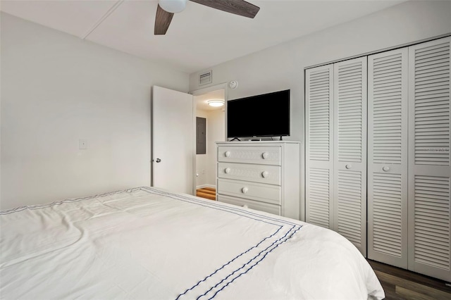 bedroom featuring dark wood-style floors, a closet, visible vents, and a ceiling fan