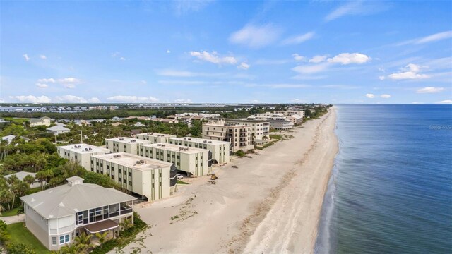 birds eye view of property with a water view and a beach view