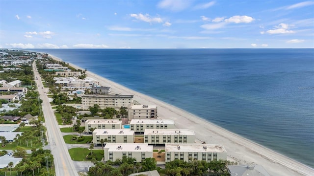 drone / aerial view featuring a beach view and a water view