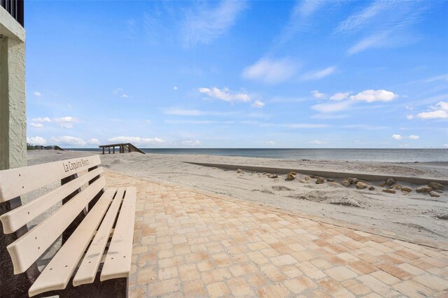 view of patio with a beach view and a water view