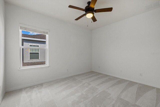 spare room with ceiling fan and light colored carpet