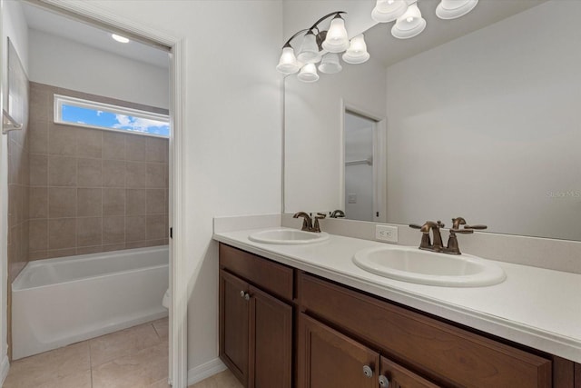 full bathroom with a chandelier, vanity, tile patterned floors, toilet, and tiled shower / bath combo