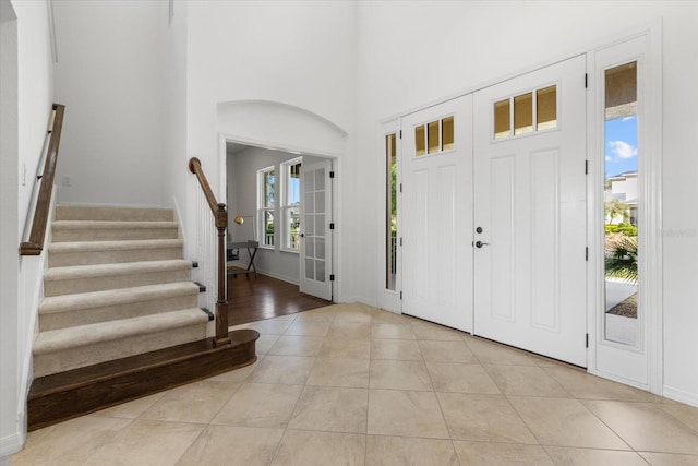 foyer with a towering ceiling and light tile patterned floors