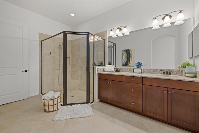 bathroom with a shower with door, vanity, and tile patterned floors