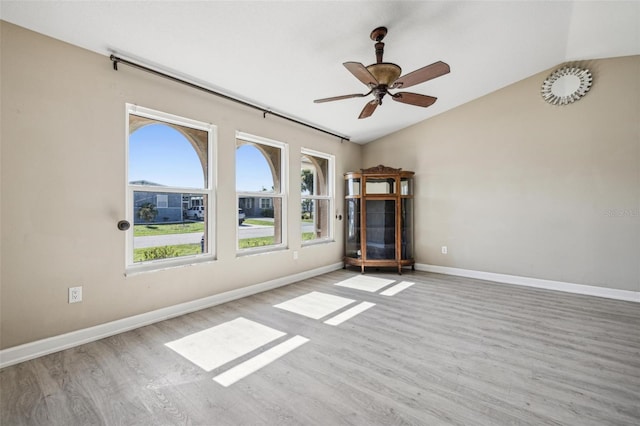 spare room featuring light hardwood / wood-style floors, ceiling fan, and lofted ceiling