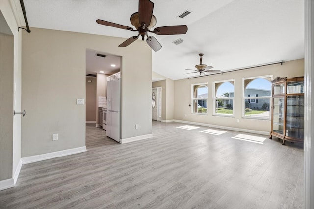 unfurnished living room with ceiling fan, vaulted ceiling, and light hardwood / wood-style flooring