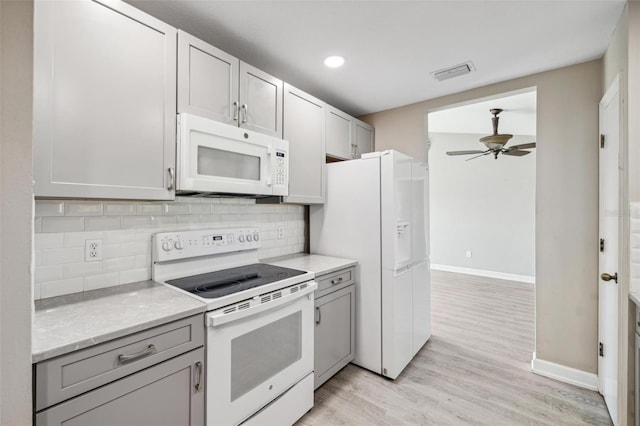 kitchen featuring backsplash, light wood-type flooring, gray cabinetry, white appliances, and ceiling fan