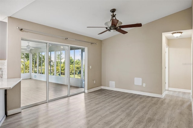 empty room featuring ceiling fan, wood-type flooring, and lofted ceiling