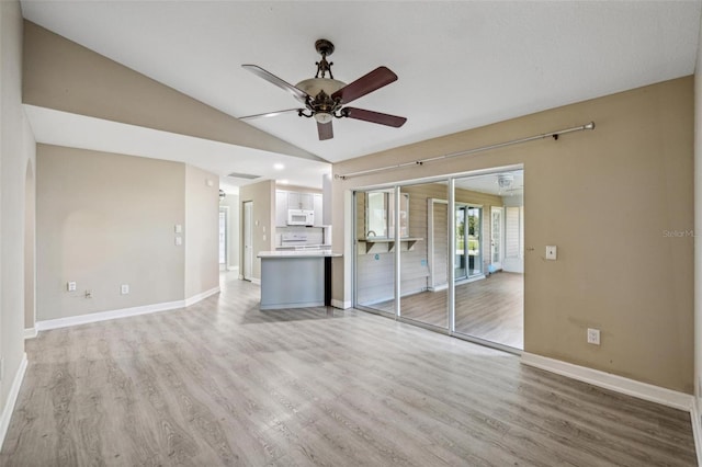 unfurnished room with ceiling fan, light wood-type flooring, and vaulted ceiling