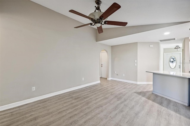 unfurnished living room with ceiling fan, light wood-type flooring, and lofted ceiling