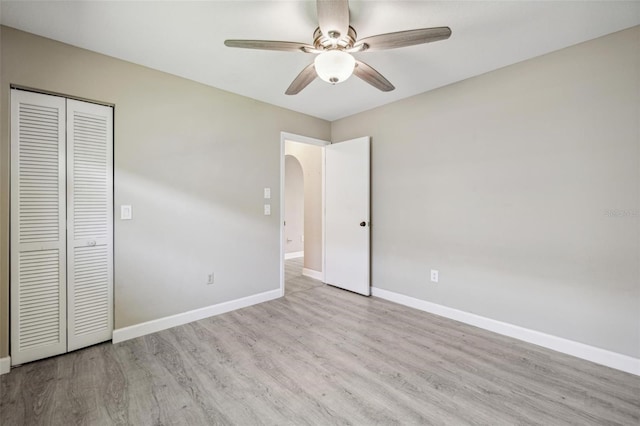 unfurnished bedroom with ceiling fan, a closet, and light hardwood / wood-style floors