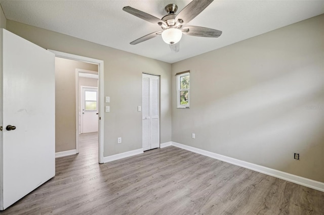 unfurnished bedroom featuring ceiling fan, a closet, and wood-type flooring