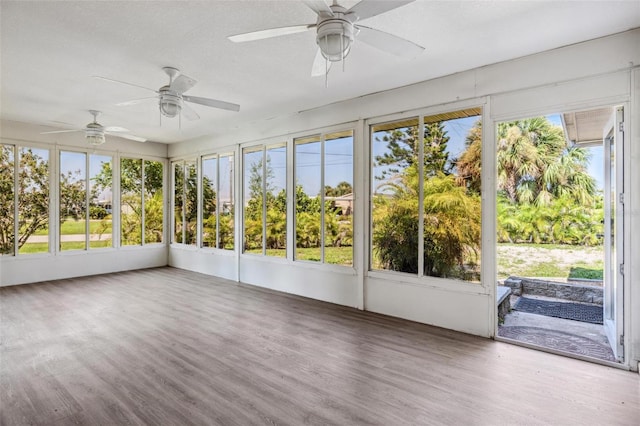 unfurnished sunroom with ceiling fan