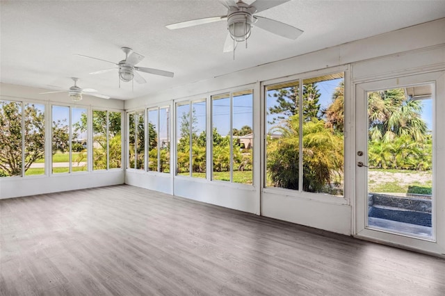 unfurnished sunroom with ceiling fan