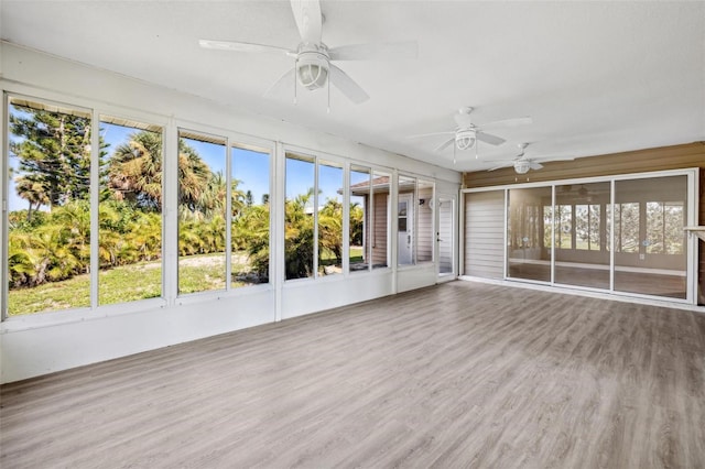 unfurnished sunroom with ceiling fan