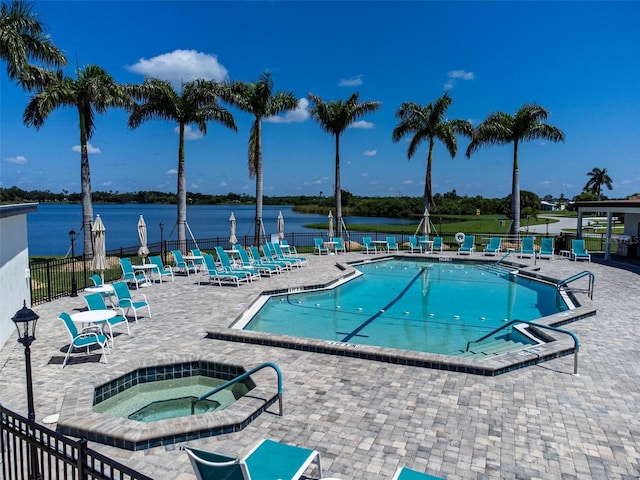 view of pool with a community hot tub, a patio area, and a water view