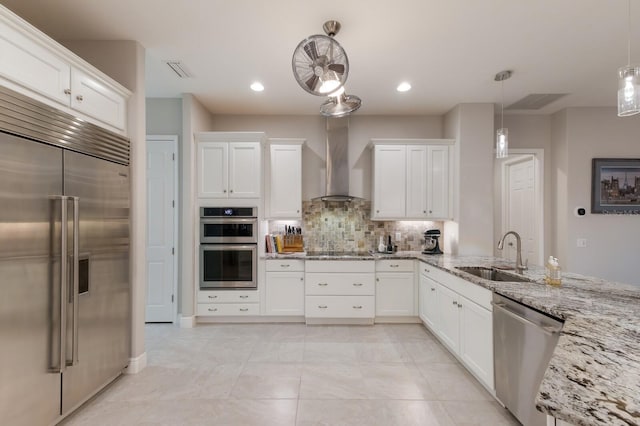 kitchen featuring stainless steel appliances, white cabinets, decorative light fixtures, and sink