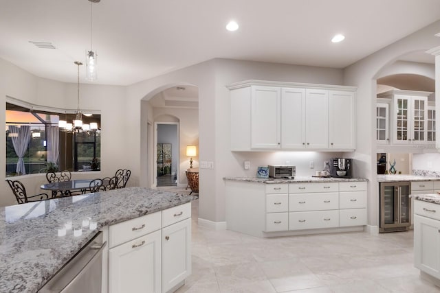 kitchen with beverage cooler, decorative light fixtures, a chandelier, and white cabinetry