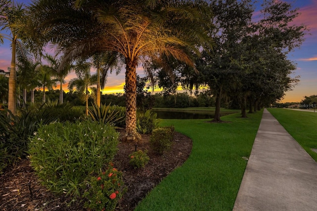 view of home's community featuring a lawn and a water view