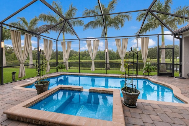 view of swimming pool featuring a yard, a lanai, a patio area, and a pool with connected hot tub