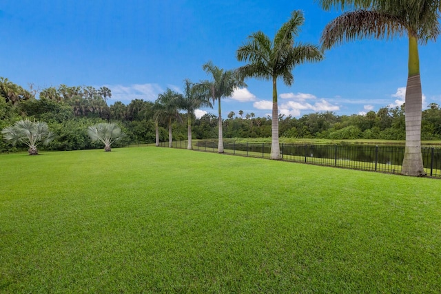 view of yard featuring a water view and fence