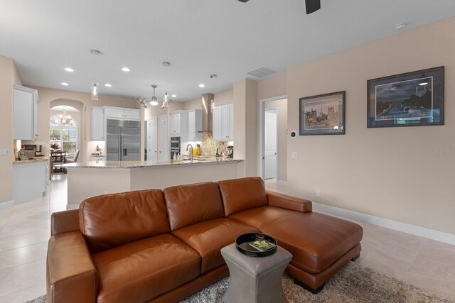 living room with a chandelier and light tile patterned flooring