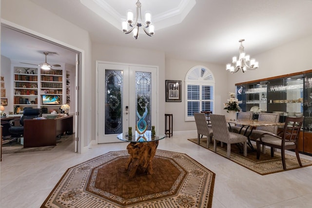 dining room with built in features, a tray ceiling, french doors, crown molding, and light tile patterned floors